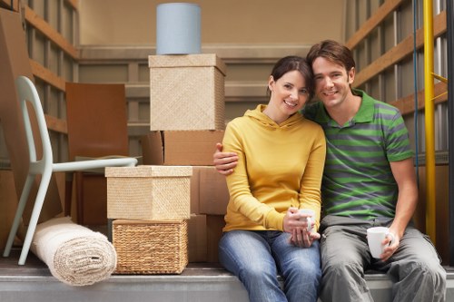 Professional movers carrying furniture at a Gidea Park property